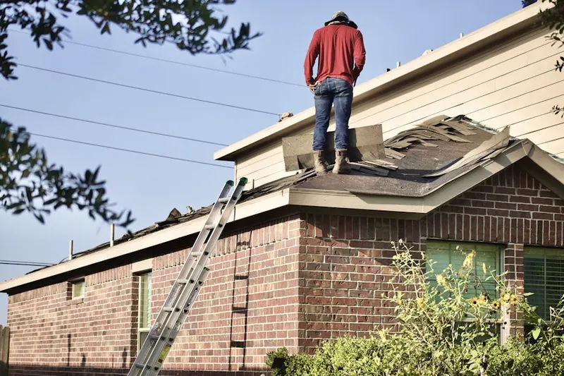 Professional roofer working on a residential roof in Fabius